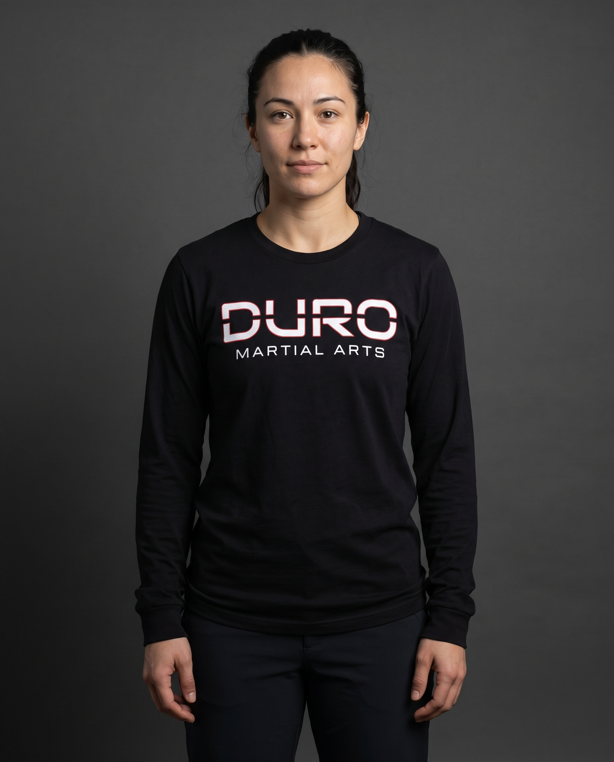 DURO Martial Arts Everyday Long Sleeve Tee modeled against a charcoal studio background — AI-generated styling image