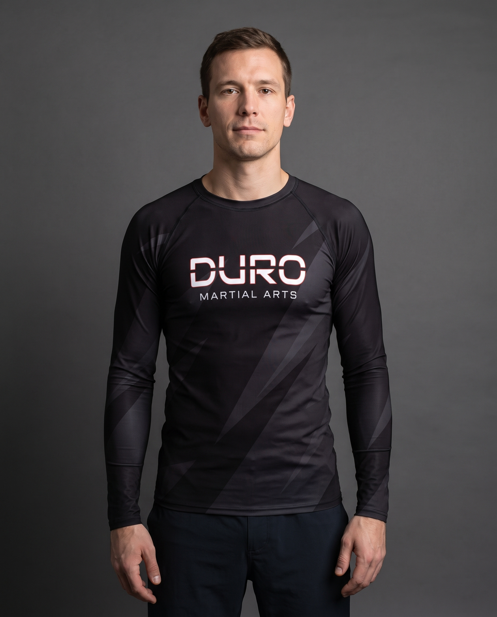 DURO Martial Arts Long-Sleeve Rash Guard modeled against a charcoal studio background — AI-generated styling image