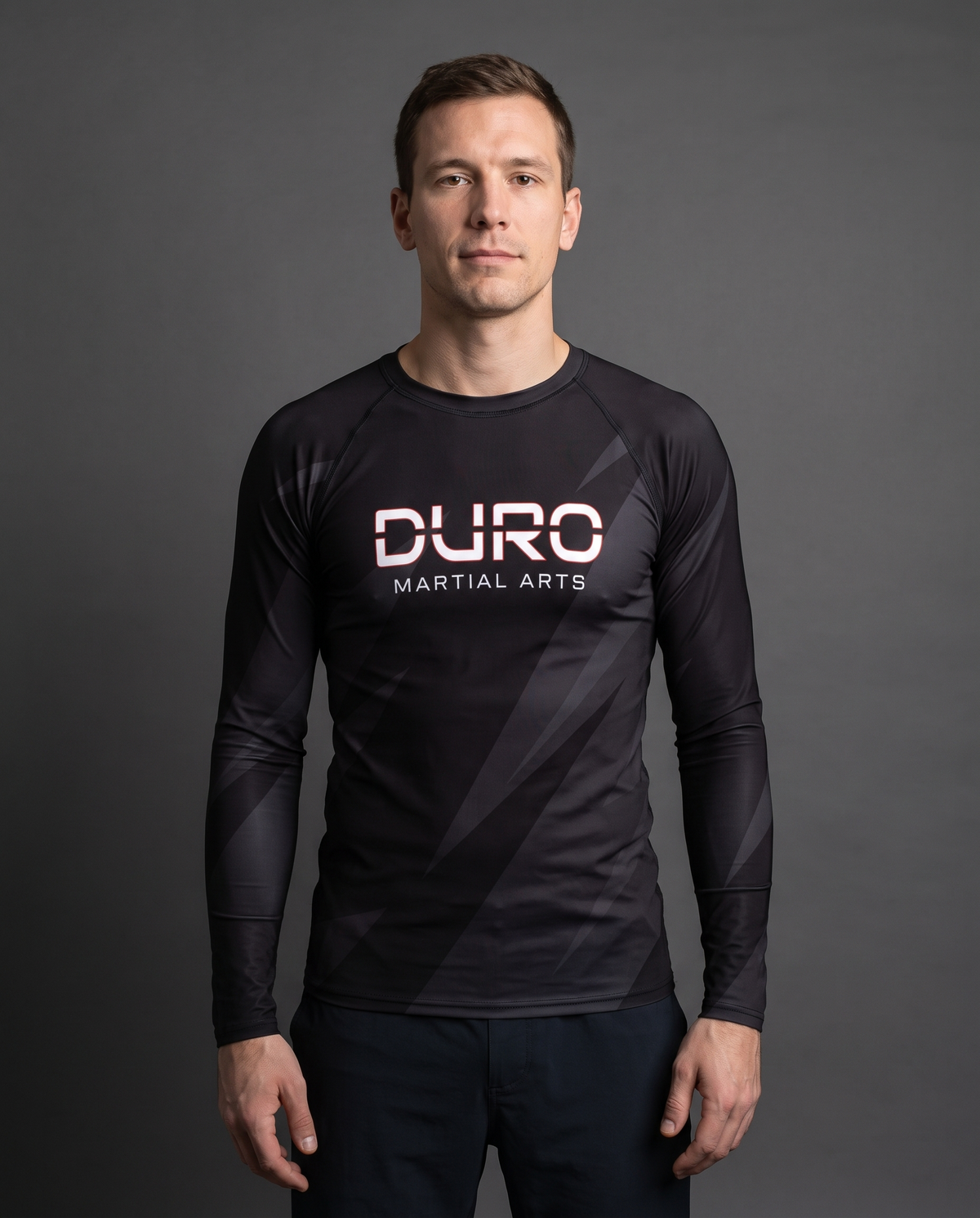 DURO Martial Arts Long-Sleeve Rash Guard modeled against a charcoal studio background — AI-generated styling image
