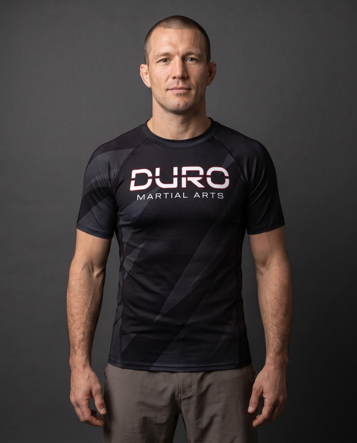 DURO Martial Arts Short-Sleeve Rash Guard modeled against a charcoal studio background — AI-generated styling image