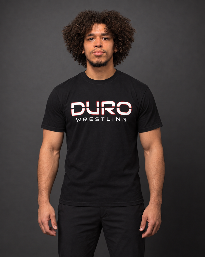 Coach X modeling the black DURO Wrestling Everyday Tee — AI-assisted studio image