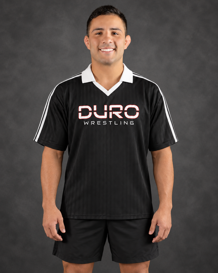 Josh modeling the DURO Wrestling Club Jersey, based on his DURO website coaching portrait — AI-assisted studio image