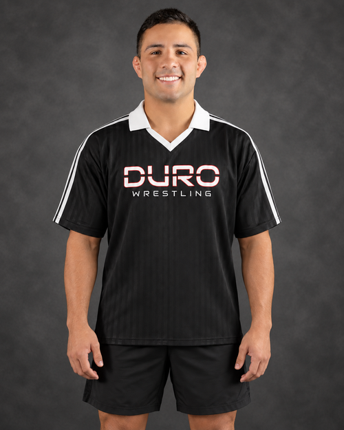 Josh modeling the DURO Wrestling Club Jersey, based on his DURO website coaching portrait — AI-assisted studio image
