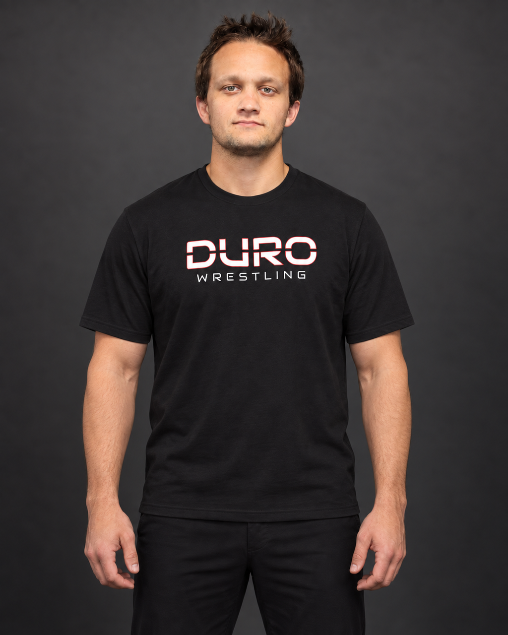 Coach Rhys Weinberger modeling the black DURO Wrestling Under Armour Training Tee — AI-assisted studio image