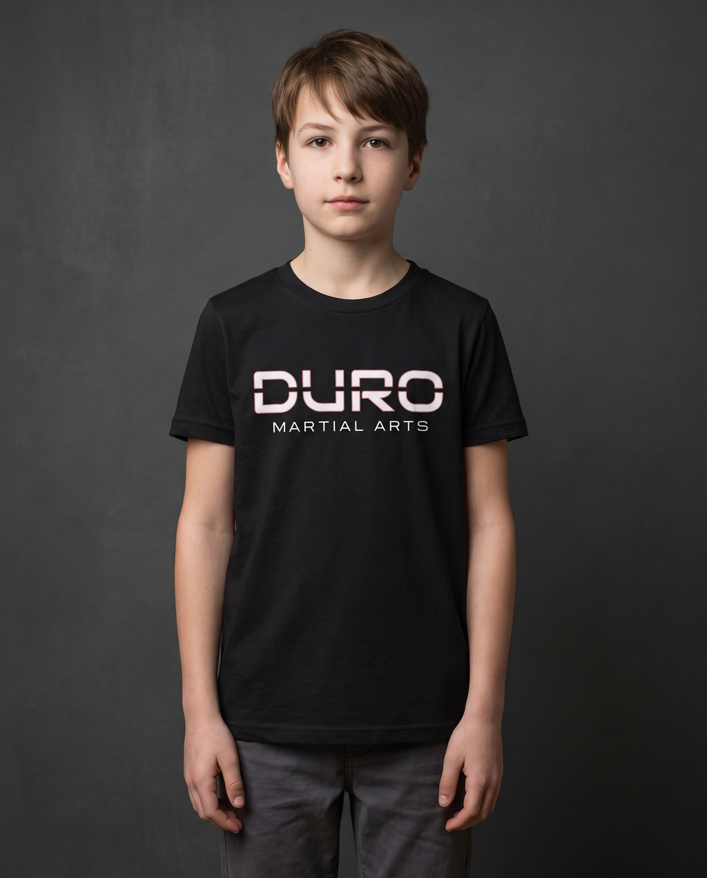 DURO Youth Martial Arts Everyday Tee modeled against a charcoal studio background — AI-generated styling image