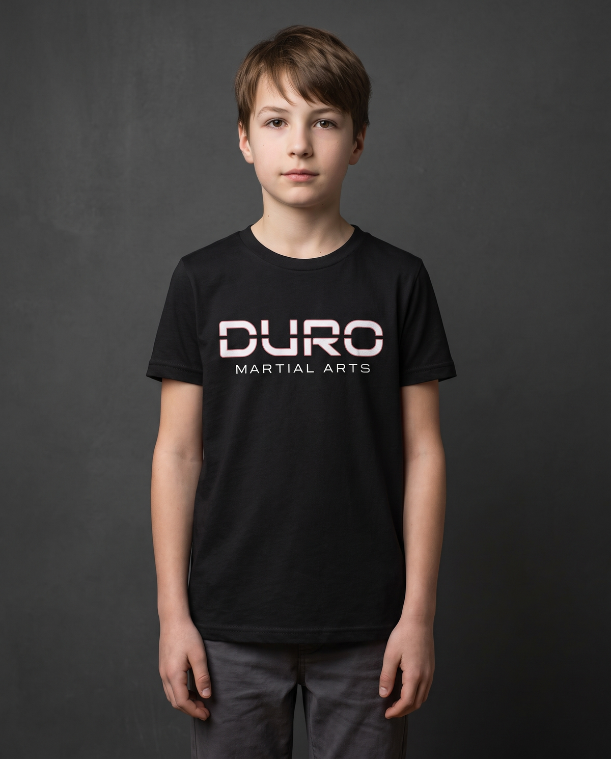 DURO Youth Martial Arts Everyday Tee modeled against a charcoal studio background — AI-generated styling image