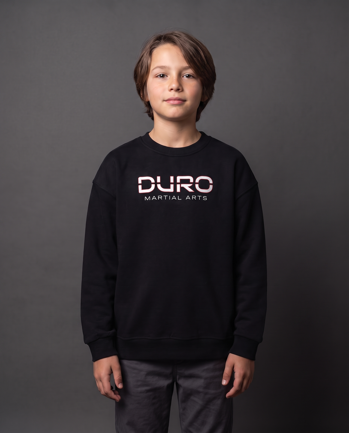 DURO Youth Martial Arts Heavyweight Fleece Crewneck modeled against a charcoal studio background — AI-generated styling image
