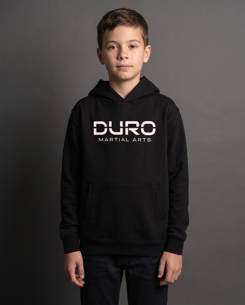 DURO Youth Martial Arts Premium Fleece Hoodie modeled against a charcoal studio background — AI-generated styling image