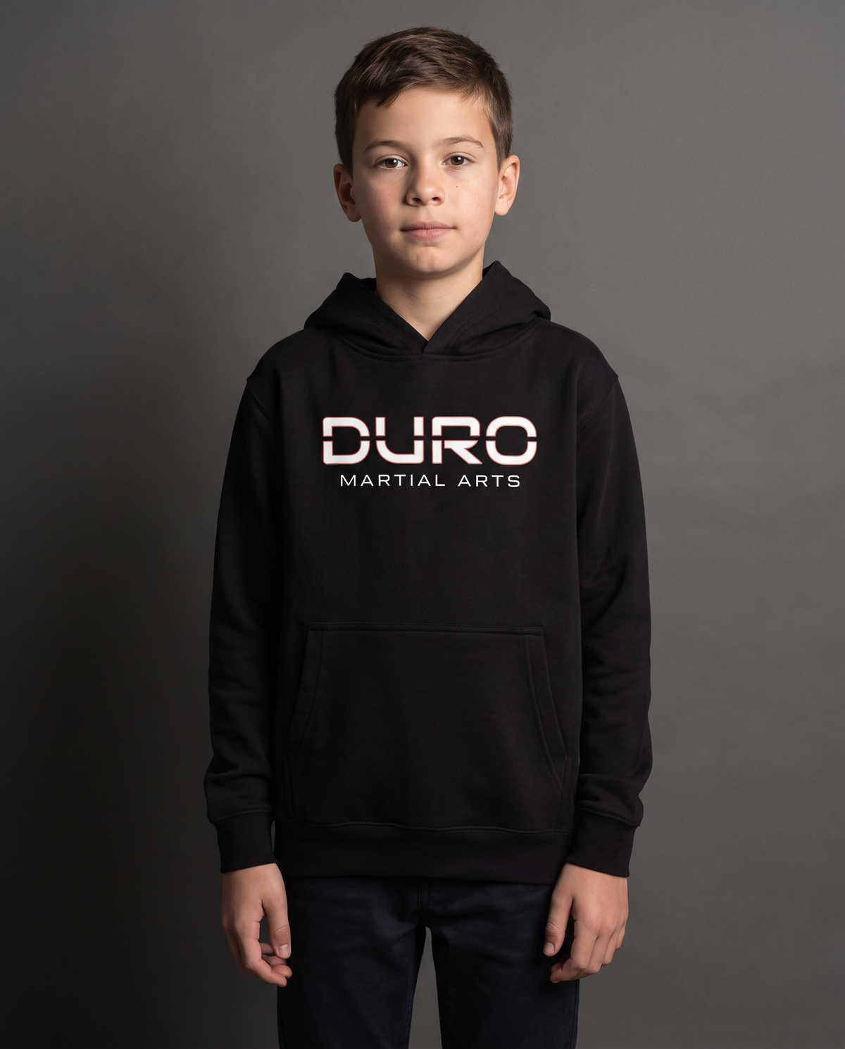 DURO Youth Martial Arts Premium Fleece Hoodie modeled against a charcoal studio background — AI-generated styling image