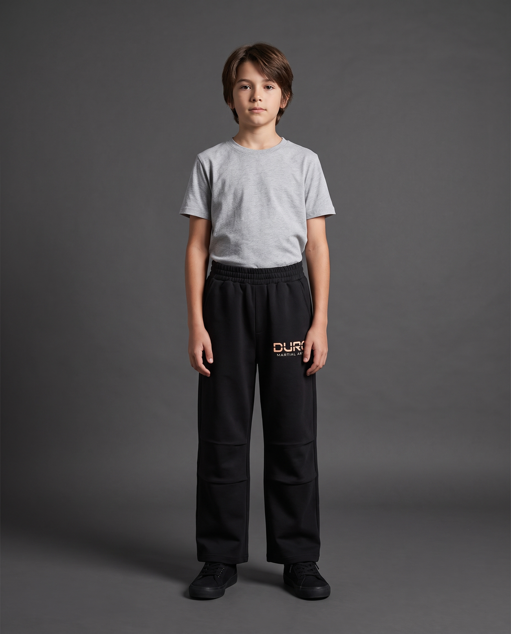 DURO Youth Martial Arts Straight-Leg Sweatpants modeled against a charcoal studio background — AI-generated styling image
