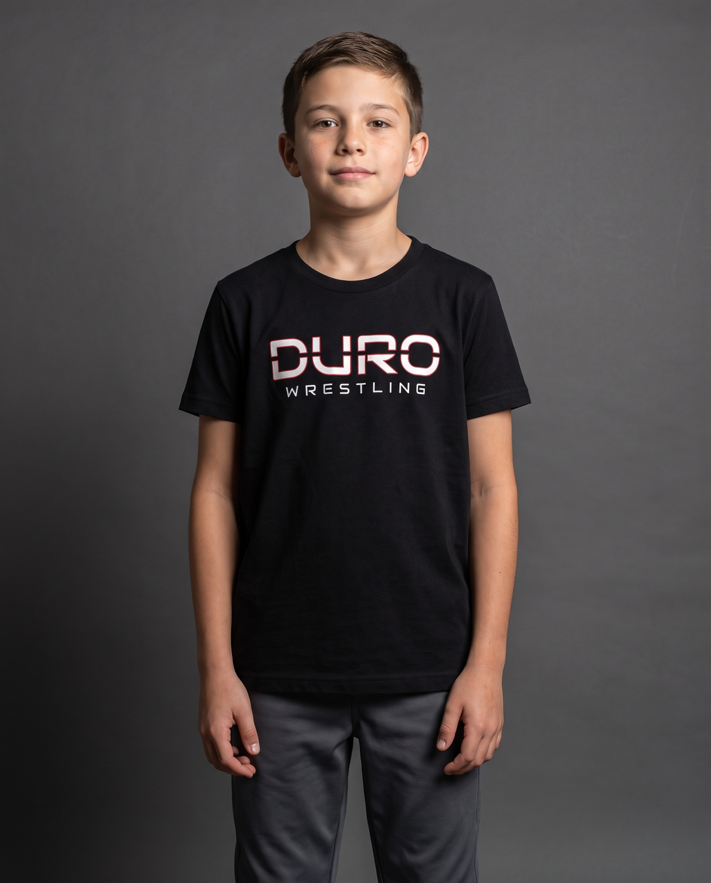 DURO Youth Wrestling Everyday Tee modeled against a charcoal studio background — AI-generated styling image