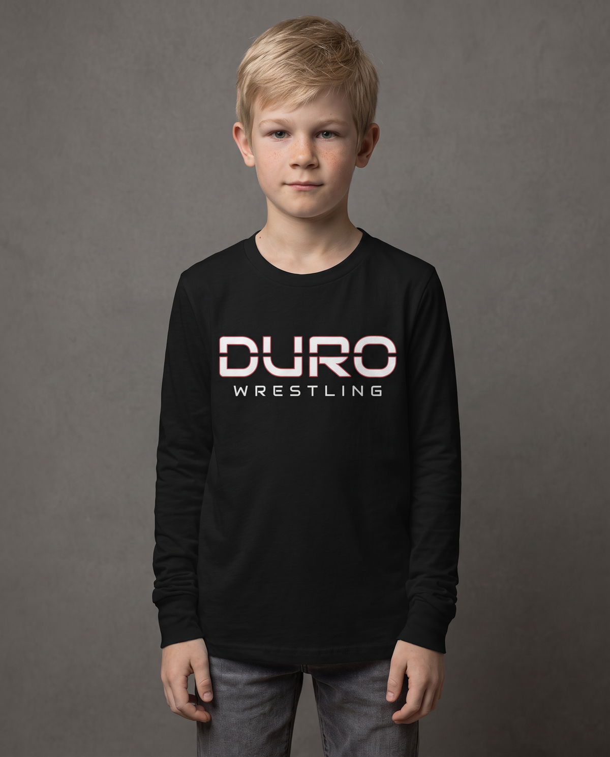 DURO Youth Wrestling Long Sleeve Tee modeled against a charcoal studio background — AI-generated styling image
